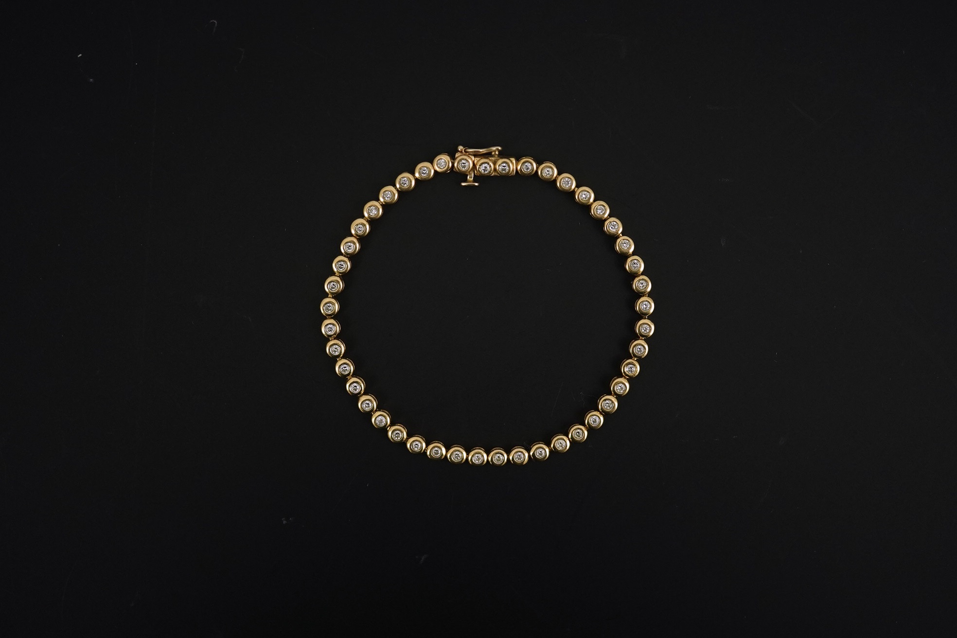 A modern gold and forty five stone round cut diamond set tennis bracelet